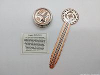 Both the pill box and bookmark shown side-by-side with a small information card describing the Copper Reflections technique of hand-drawn screen printing on copper with a protective acrylic finish.