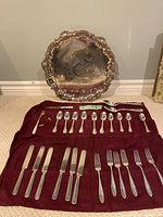 View of assorted silver plate flatware including knives, forks, spoons, and a large ornate serving tray