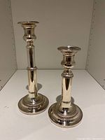 Pair of silver plated telescopic candlesticks showing full height difference.