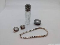 Full lot showing sterling silver bracelet, pill box, earrings, and cut glass vanity bottle.