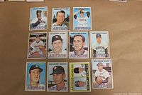 Top view of all 11 assorted 1967 Topps Houston Astros baseball cards laid out on a flat surface showing players' images and team logo.