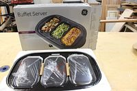 GE Buffet Server with three small trays covered in plastic and original box visible behind.