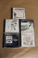 Five CD cases arranged showing all title covers including The Best of Clyde, That Wonderful Old Two-Holer, Slow Lane Maine, Hunting and Fishing Guide in Maine, and Tall Tales and Damn Lies
