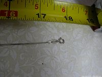Photo of the necklace end with spring ring clasp and measuring tape showing length around 18 inches.