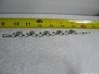 Full length of sterling silver bracelet measured against a ruler, showing approx. 7.5 inches length.