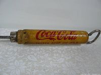 Photo of the wooden handle with Coca-Cola logo and slogan, showing the condition and branding.