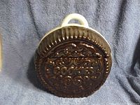 Cookie jar shaped like an Oreo cookie, front view with lid in place, showing embossed word 'cookies' and textured design mimicking the cookie surface.