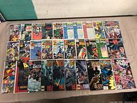 Full lot overview of comic books laid out in rows on table, showing Batman, Spider-Man, Star Wars, Superman, and others