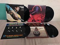 Four LP record albums displayed, showing covers and vinyl records. Albums include Johnny Cash, The Beach Boys, The Bugs, DECADE.