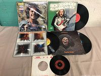 Photo showing five vinyl records including George Rowsell 'Hotel Gander', Rick Derringer 'All American Boy', Focus 'Live at the Rainbow', Funkadelic 'Maggot Brain' LP albums plus a Focus 45rpm single record.