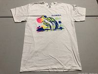 Front view of white vintage Florida T-shirt with bird and sunset graphic