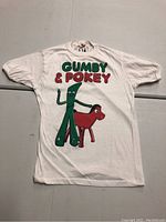 Front of white vintage T-shirt showing Gumby and Pokey characters with large green and red lettering on front.