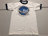 Full front view of the white vintage Louisiana World Expo T-shirt with navy collar and sleeve edges, showing the event logo and dates.