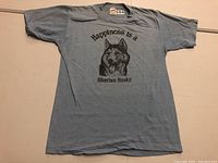 Full front view of gray T-shirt laid flat showing graphic and text