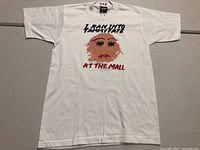 Full front view of the white T-shirt showing the graphic and text.
