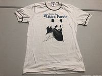 Full view of the white T-shirt with the giant panda graphic and text.