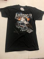 Full front view of black vintage T-shirt laid flat on surface showing front graphic design and tag