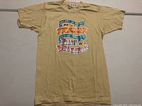 Full front view of vintage beige T-shirt with colorful trucking-related graphic
