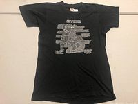 Full front view of black vintage trucker T-shirt with white graphic and text.