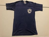 Full front photo of navy blue T-shirt with polar bear and location text.