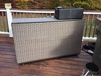 Outdoor patio bar on deck, showing full front and side synthetic wicker weave and flat top