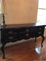 Front view of the Bassett buffet showing the six drawers with brass handles and cabriole legs.