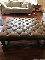 Front view showing full padded leather top and living room setting.