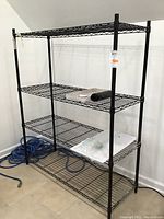 Black wire shelving rack showing full structure and four shelves