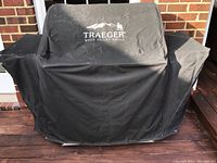 Grill fully covered by black fitted Traeger cover