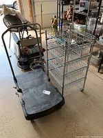 Uline mini rolling cart with four wire baskets next to Rubbermaid black plastic dolly with handle