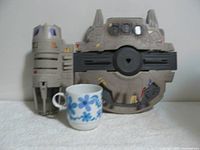 Front view of the Dash Rendar's Outrider toy for size reference with a cup.
