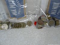 Two zip lock plastic bags each containing a mix of coins, one bag contains coins totaling 19 pounds as label indicates, second bag contains coins totaling 29 euros as labeled.