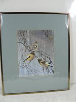 Framed print of three birds on branches with green mat and metallic frame