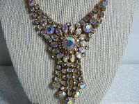Close-up of pendant showing intricate aurora borealis rhinestone arrangement with central large stone and dangling fringe detail.