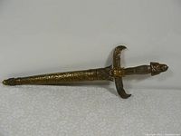 Full view of the dagger in its sheath, showing the overall shape and metal finish