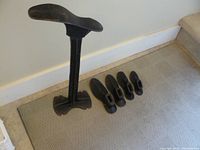 Photo showing the full cobbler stand and five shoe lasts lined up on the floor.