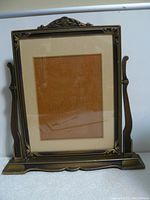 Front view of the vintage wooden swivel photo frame showing the carved decorative edges and base stand.