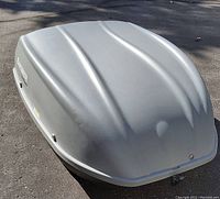 Closed gray Explorer SportRack rooftop cargo carrier showing aerodynamic ridged top surface and front-facing lock.
