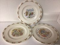 Three Royal Doulton Bunnykins ceramic plates arranged for front view showing colorful bunny-themed illustrations and decorative borders.