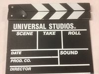 Front of clapperboard with Universal Studios branding and white text sections for production info.