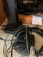 Black wired stereo headphones bundled with cable, placed on carpet near wooden step