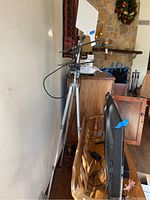 Homemade directional antenna mounted on tripod with white square panel and horizontal rods, positioned near a wall in a living room setting.