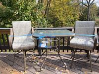 Full view of glass top table with two bar height swivel arm chairs on deck showing condition and setup.