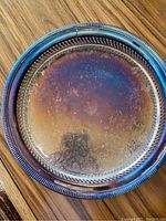 Round William Rogers silver-plated tray with decorative edges showing slight tarnishing and patina.