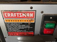 Close-up of the Craftsman Professional metal label on the jointer planer with specifications and start/stop buttons.