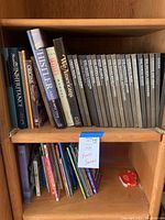 Books on a wooden shelf showing two rows of books including the Time-Life Wilderness series on the right and various other books on the left including art and children's books.