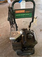 Top-down view of Craftsman pressure washer showing motor, fuel tank, coiled hose, and exhaust guard.