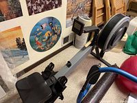 Full side view of rowing machine showing frame, seat, footrests, and flywheel housing
