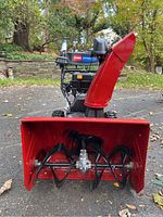 Front view showing red steel two-stage auger housing and intake