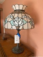Photo of table lamp showing Tiffany-style stained glass shade and heavy metal base